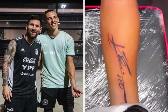 Lionel Messi signs fan's arm after receiving award