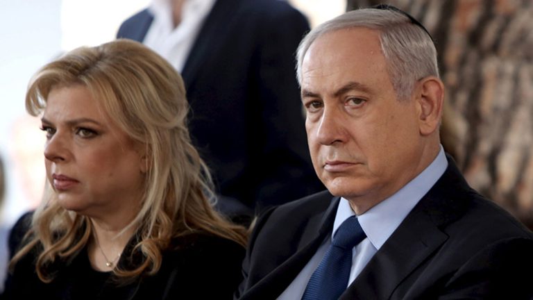 Israeli Prime Minister Benjamin Netanyahu sits with his wife Sara during the state funeral ceremony of Israel's former president Yitzhak Navon at the Mt. Herzl Cemetery in Jerusalem